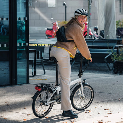 Person with a bicycle Dahon Hit i3 on a sidewalk in an urban setting